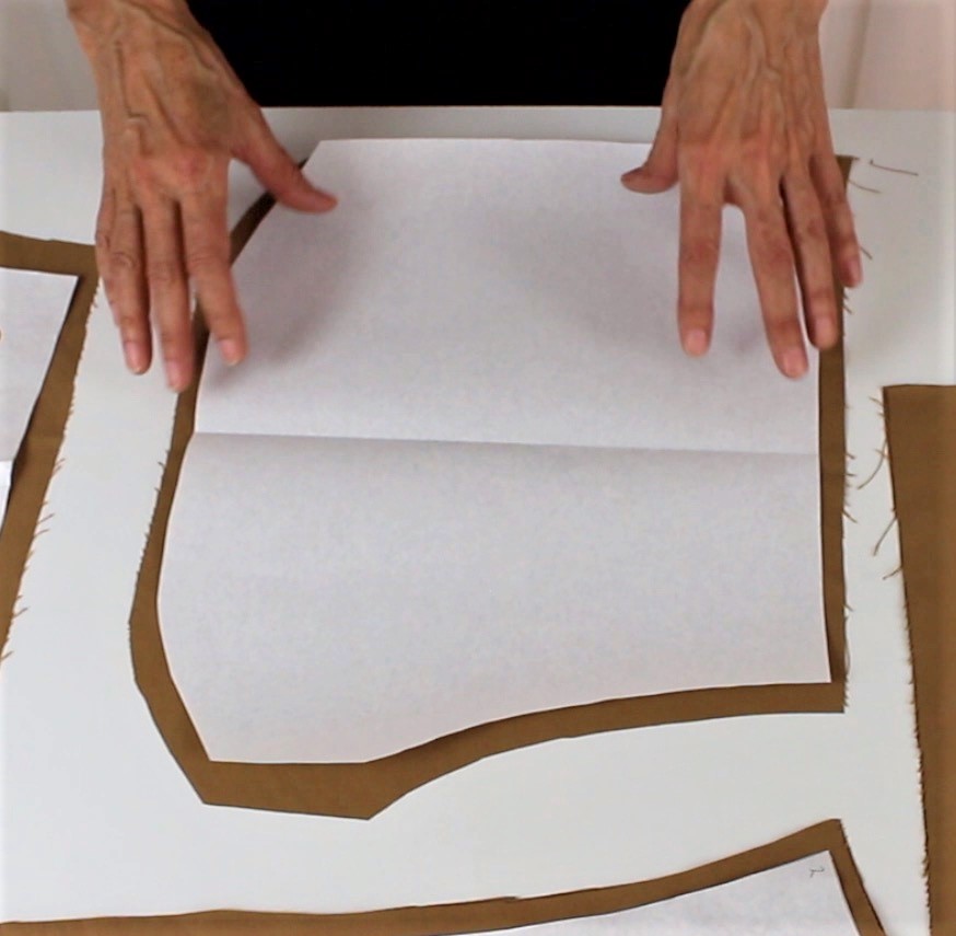 Brauner Stoff und weißes Schnittmuster; DIY, selbstgemachte Mode; präzise und modisch.