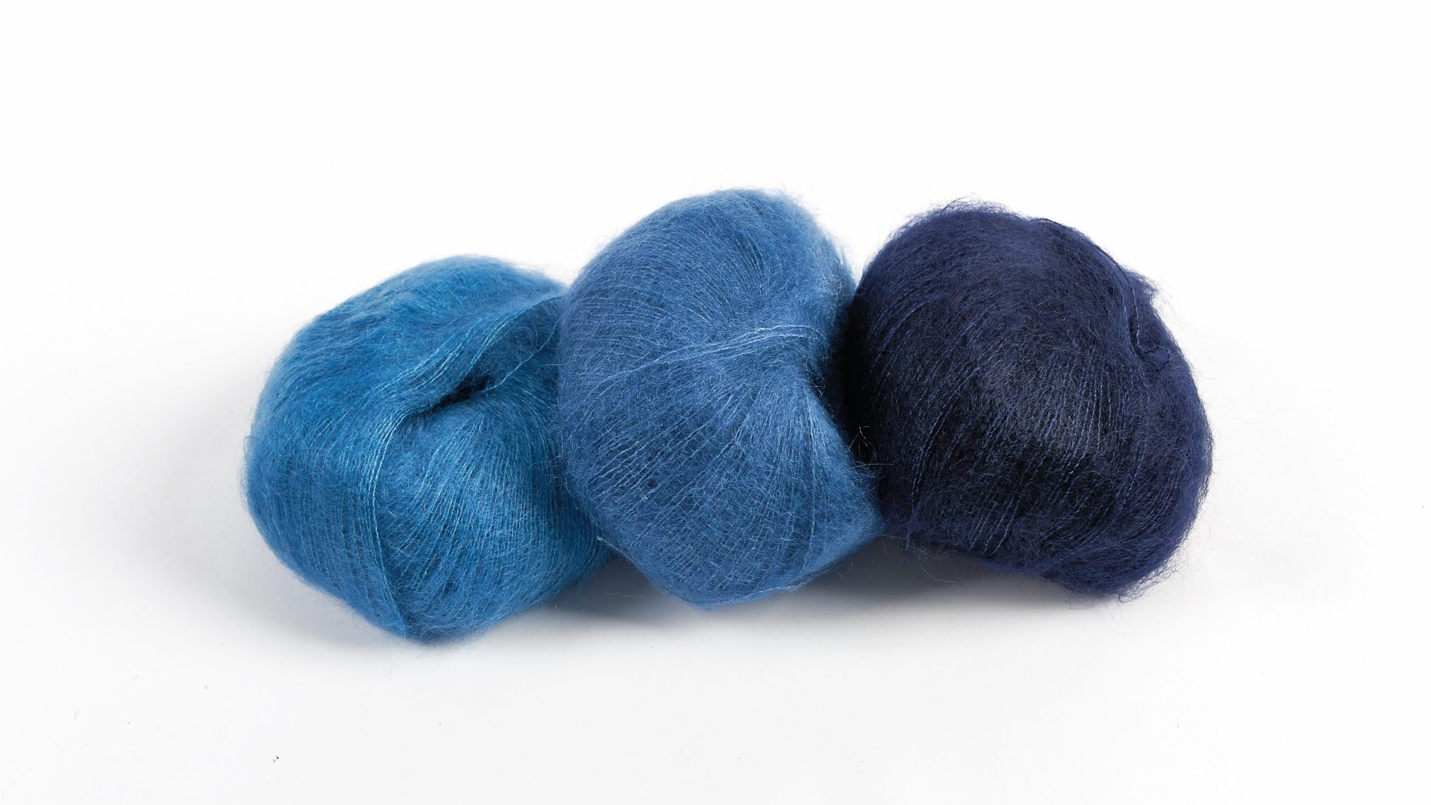 Drei Wollknäuel in sanften Blautönen, perfekt für modische Handarbeit und DIY-Projekte.